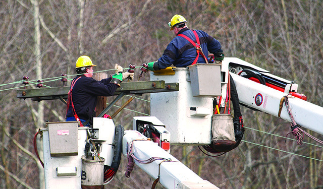 Lineman in crane working on a light pole using MobiWork utilities services software solution
